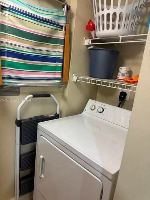 Utility area featuring a top-load washer, wall-mounted drying rack, and two levels of wire shelving