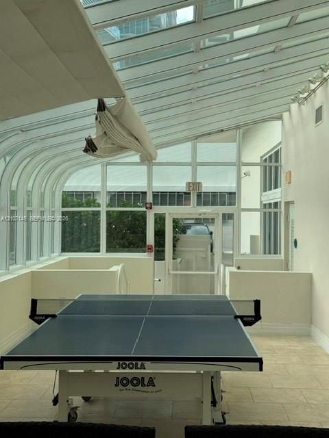 Sunroom featuring a curved glass roof, floor-to-ceiling windows, and tile flooring