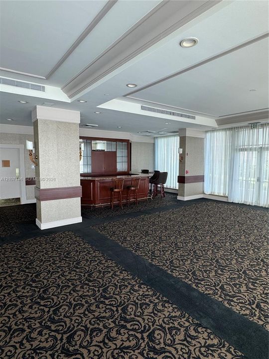 Built-in bar with wood cabinetry and countertop, recessed ceiling lighting, decorative crown molding, and large-scale floor-to-ceiling windows