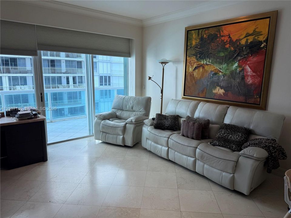 Large-format stone tile flooring, floor-to-ceiling glass sliding doors, and crown molding