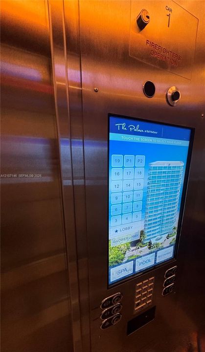 Brushed stainless steel elevator interior featuring a digital touchscreen interface, integrated key-operated control system, and emergency operation panel