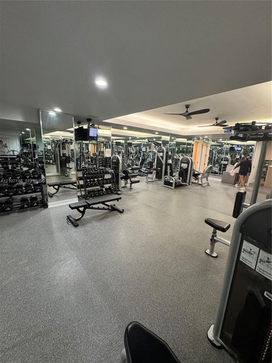 Fitness center featuring wall-to-wall mirrors, recessed lighting, ceiling fans, and slip-resistant flooring