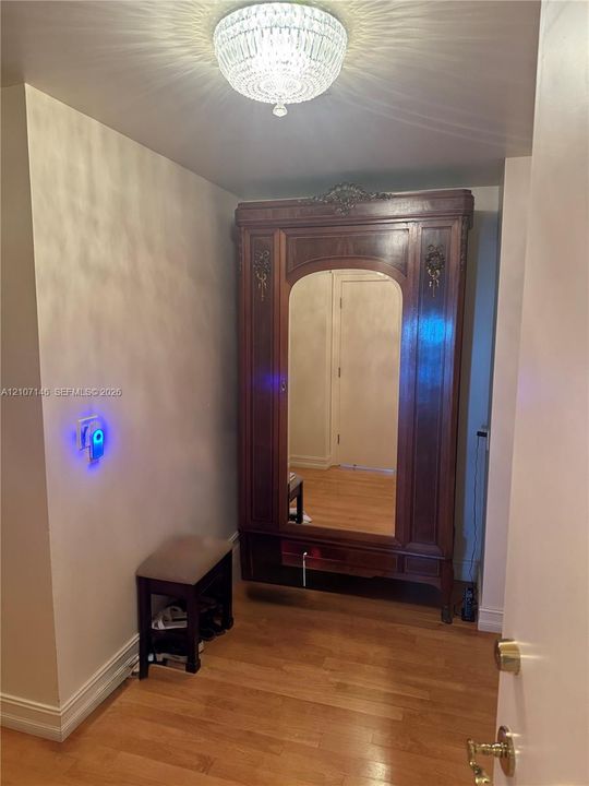 Wood-finish flooring and a crystal-style flush mount ceiling light