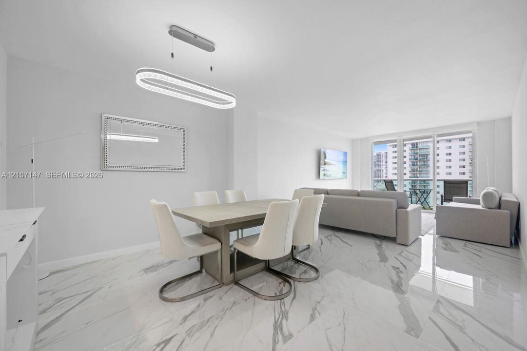 Polished stone-finish flooring, modern oval LED pendant lighting, and full-height glass balcony doors