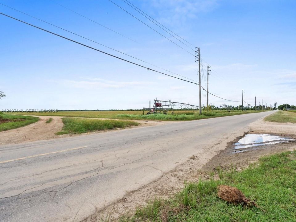 Expansive rural acreage featuring paved road frontage, utility infrastructure, and agricultural irrigation equipment