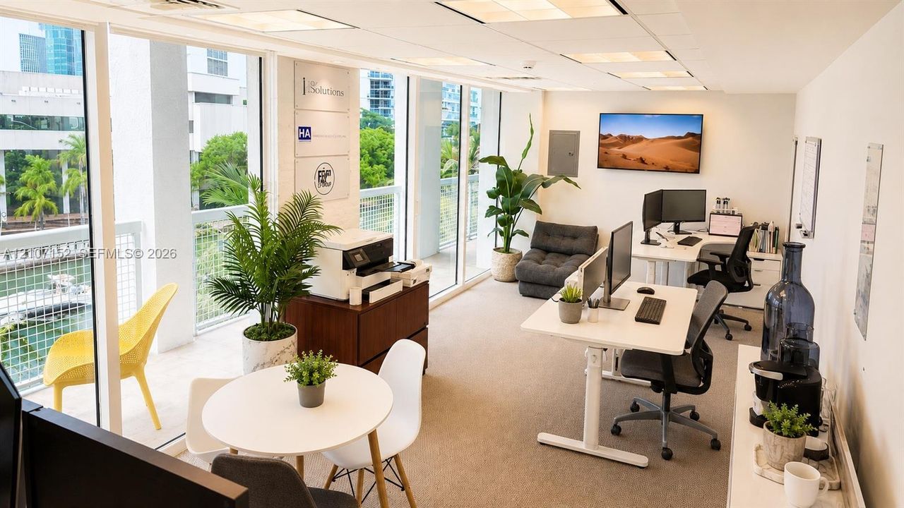 Office space featuring floor-to-ceiling windows, neutral carpeting, recessed ceiling lighting, and a private balcony with metal railings