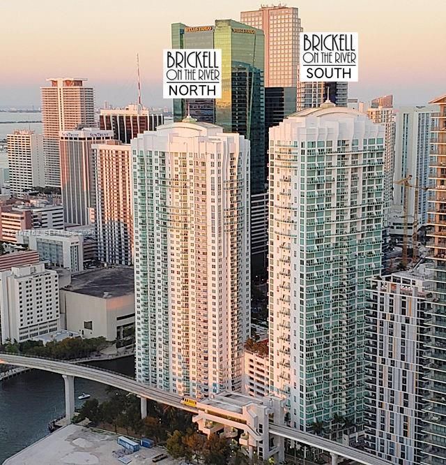 Aerial perspective of high-rise residential towers featuring glass facades, private balconies, and proximity to urban infrastructure