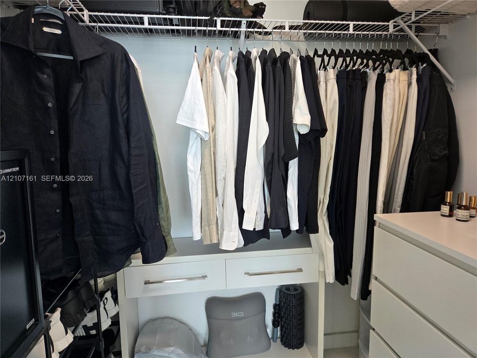 Storage area featuring white built-in cabinetry with two pull-out drawers and integrated wire shelving