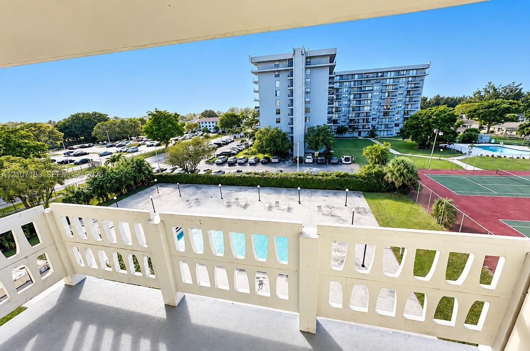 Private balcony featuring concrete flooring and geometric decorative concrete railings, accessible via full-height sliding glass doors