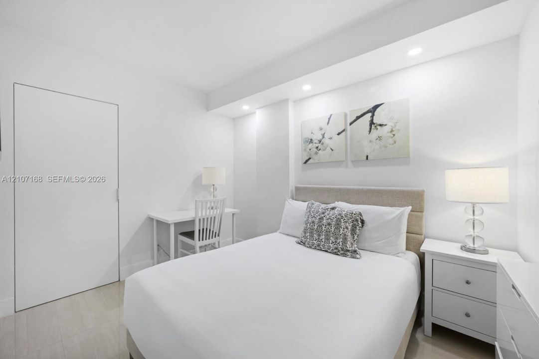 Room featuring recessed lighting, a smooth-finish door, and neutral-tone flooring