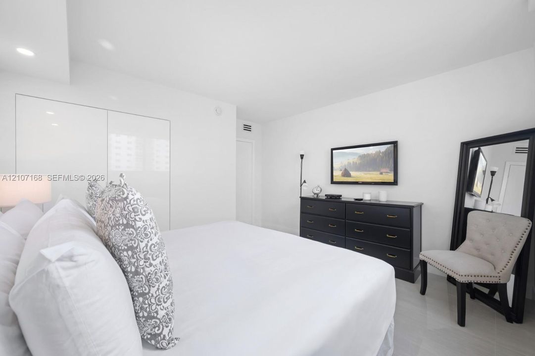 Interior space featuring recessed lighting, high-gloss floor-to-ceiling built-in cabinetry, and neutral tile flooring