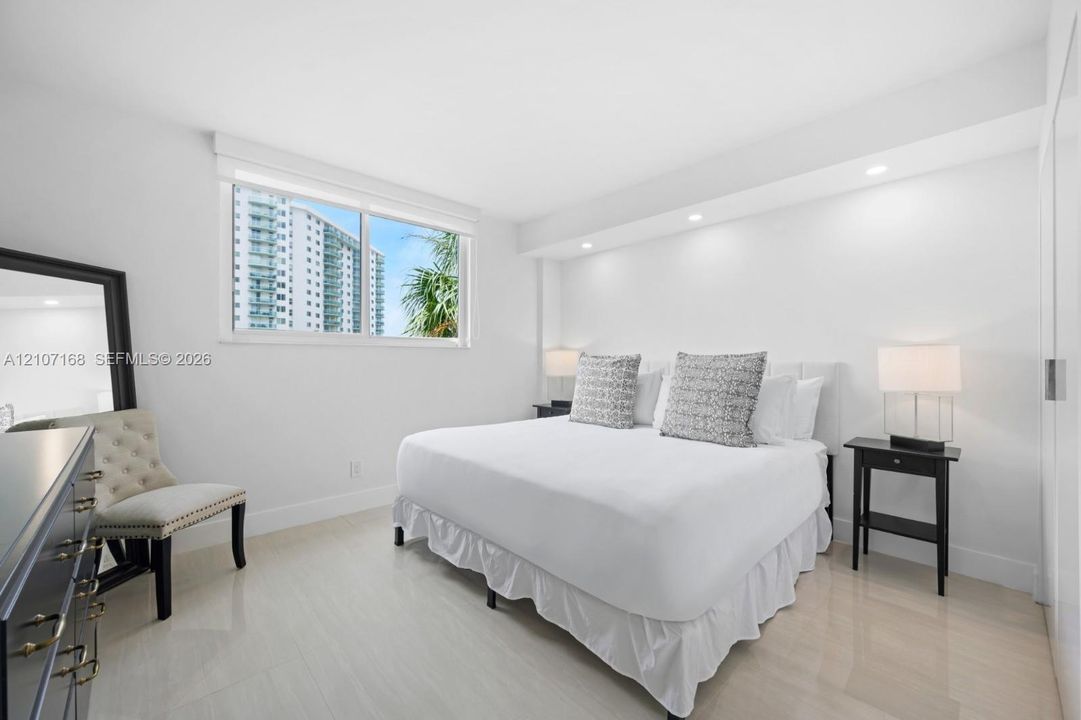 Recessed ceiling lighting, wide-format window, and polished tile flooring