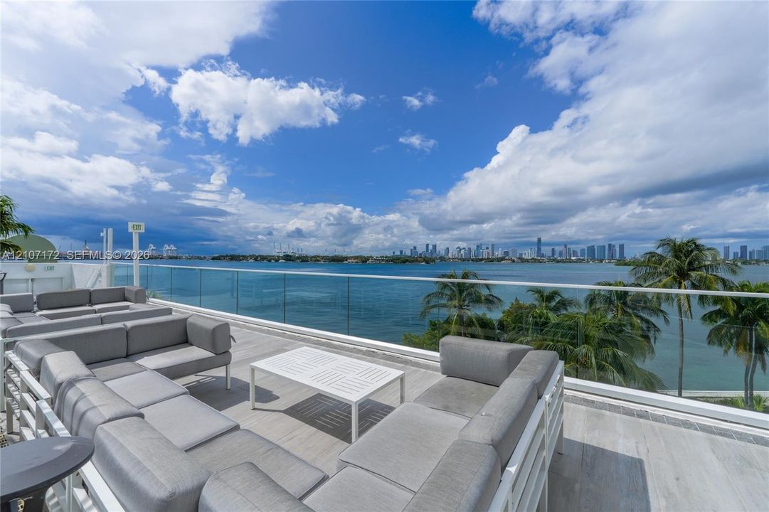 Expansive rooftop terrace featuring large-format tile flooring and a frameless glass perimeter railing