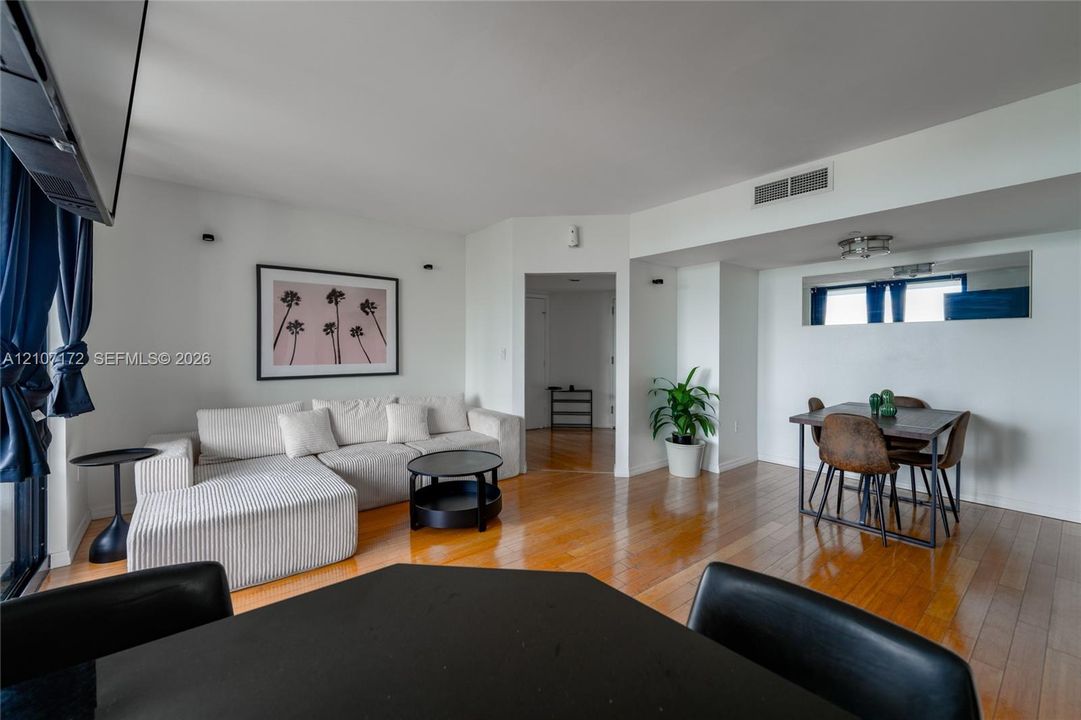 Open floor plan featuring wood-finish flooring, recessed wall lighting, and a mirrored wall accent