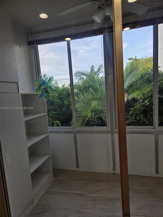 Floor-to-ceiling windows, built-in shelving, tile flooring, and recessed ceiling lighting