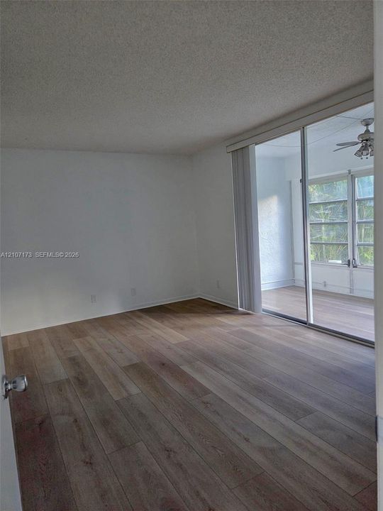 Wood-finish flooring, sliding glass door, and recessed ceiling texture