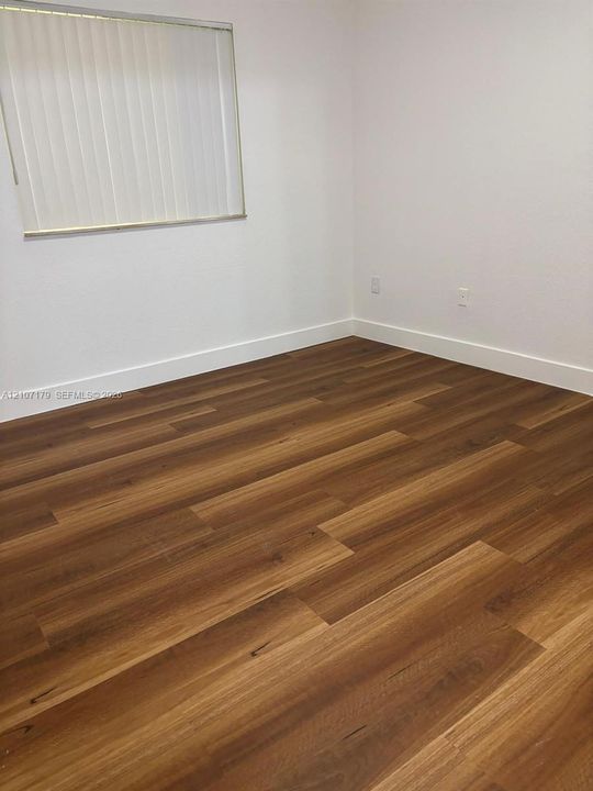 Interior room featuring neutral wall finishes and wood-finish flooring