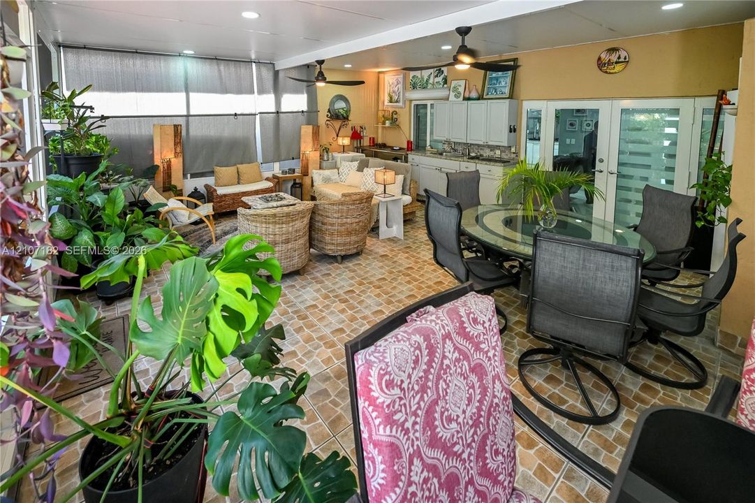 Enclosed patio featuring tile flooring, built-in cabinetry, recessed lighting, and dual ceiling fans