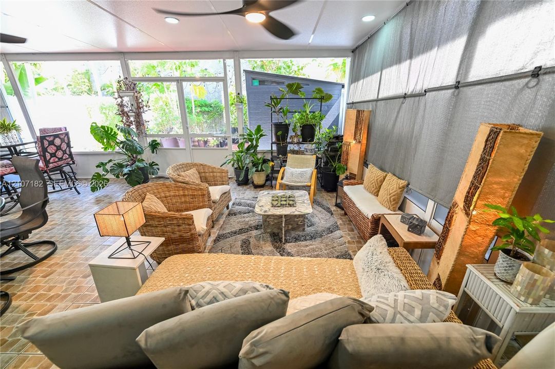 Screened-in patio featuring decorative tile flooring, ceiling-mounted fan, recessed lighting, and large screen panels
