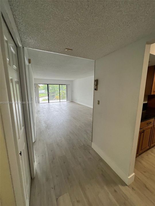 Open-concept floor plan featuring wood-finish flooring, floor-to-ceiling sliding glass doors, and recessed lighting