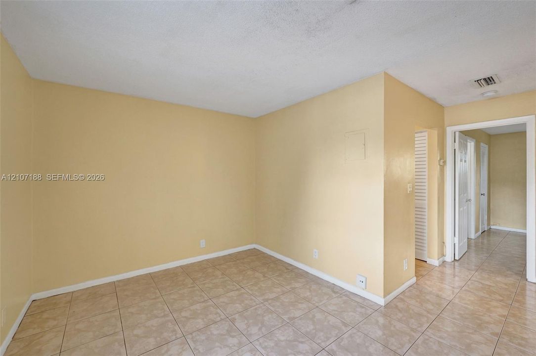 Interior space featuring neutral wall paint, large-format ceramic tile flooring, and louvered bifold closet doors