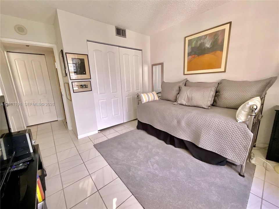Neutral ceramic tile flooring and white paneled closet doors