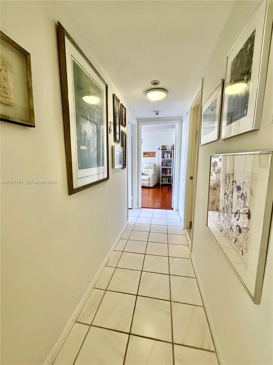 Hallway featuring large-format square tile flooring and neutral wall tones