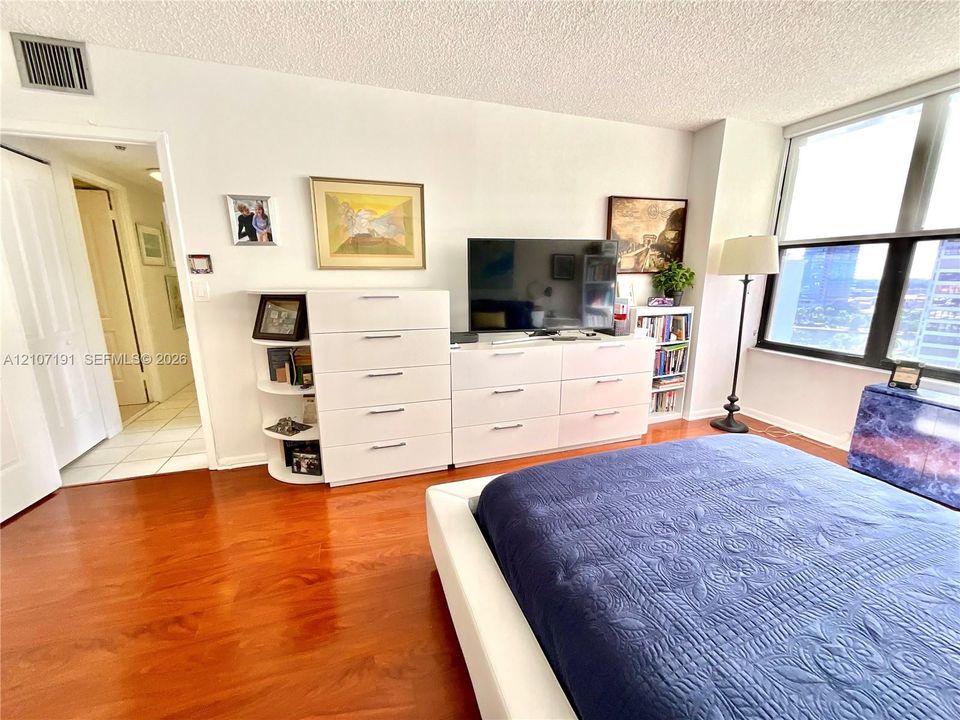 Wood-finish flooring, floor-to-ceiling windows, and white-finish interior doors