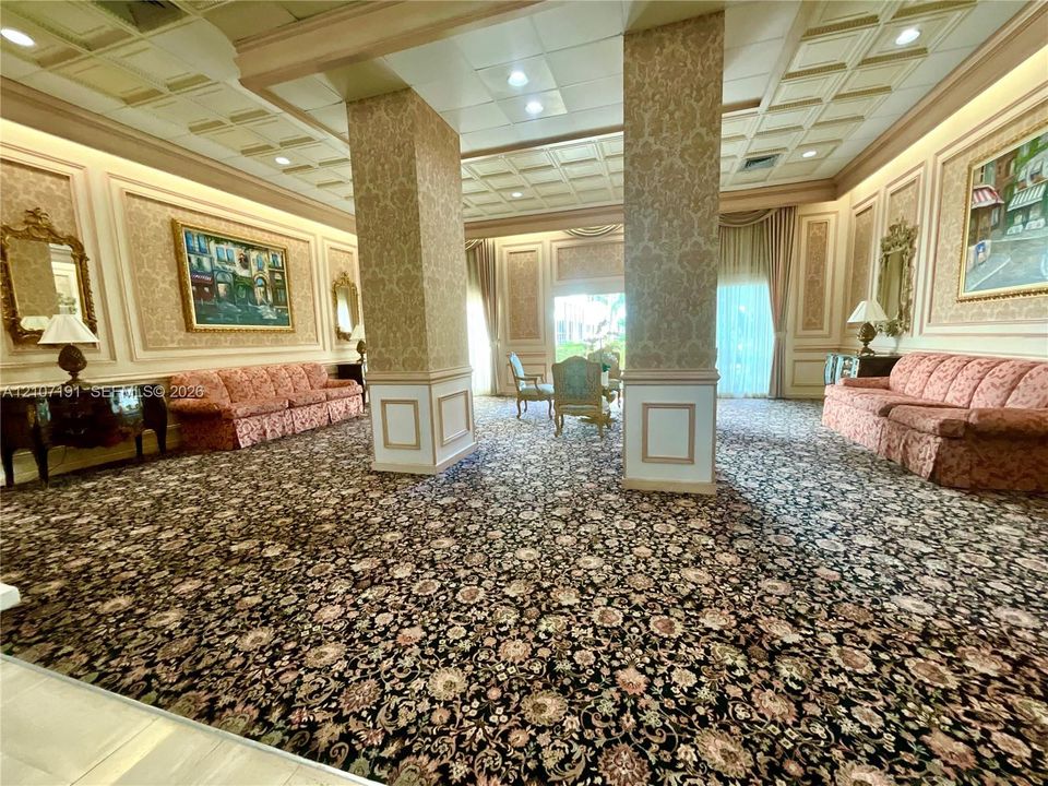 Coffered ceiling, structural columns with wallpaper finish, elaborate wall molding, and patterned wall coverings