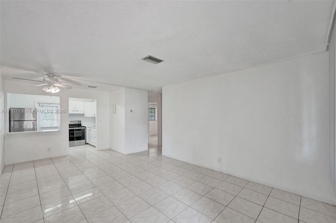 Interior space featuring light-toned tile flooring, recessed ceiling lighting, and a white ceiling fan