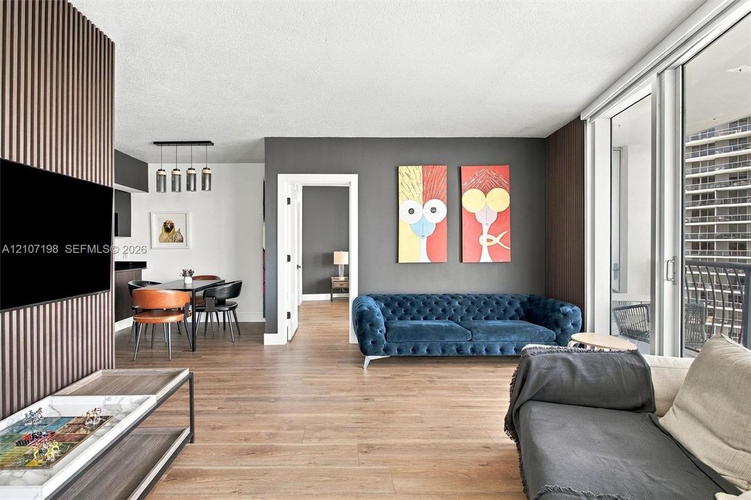 Interior space featuring wood-finish flooring, floor-to-ceiling sliding glass doors, and a vertical slat accent wall