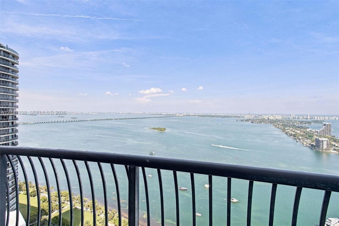 Private balcony with black metal railing and unobstructed panoramic water scenery