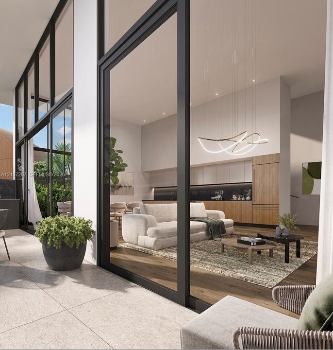 Floor-to-ceiling glass wall panels with black framing, wood-finish flooring, custom wood-veneer cabinetry, recessed ceiling lighting, and sculptural LED pendant lighting