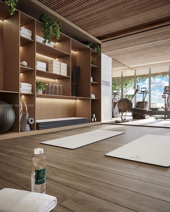 Yoga and pilates Floor-to-ceiling custom wood shelving with integrated LED lighting, linear wood-slat ceiling, wood-finish flooring, and expansive floor-to-ceiling windows. Sauna and showers
