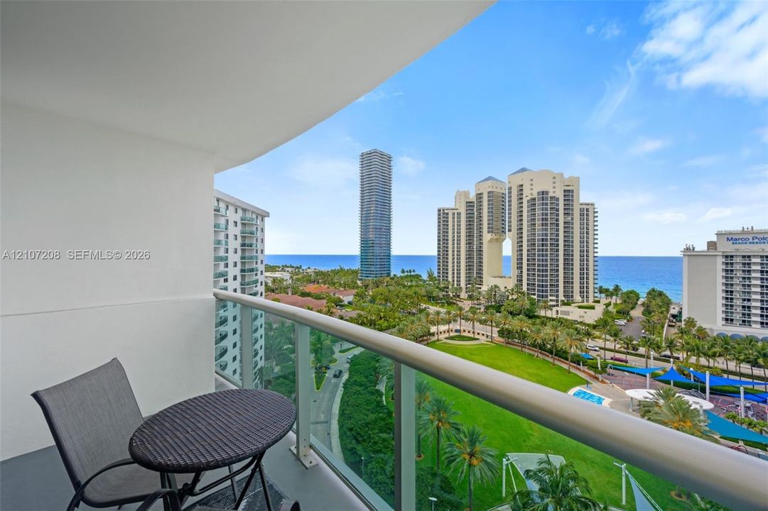 Private balcony with glass panel railing and painted concrete flooring