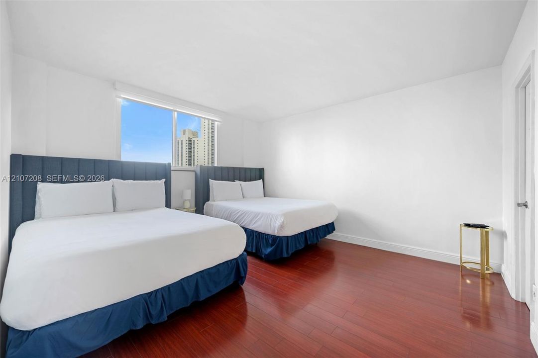Room featuring wood-finish flooring, large window, and neutral walls
