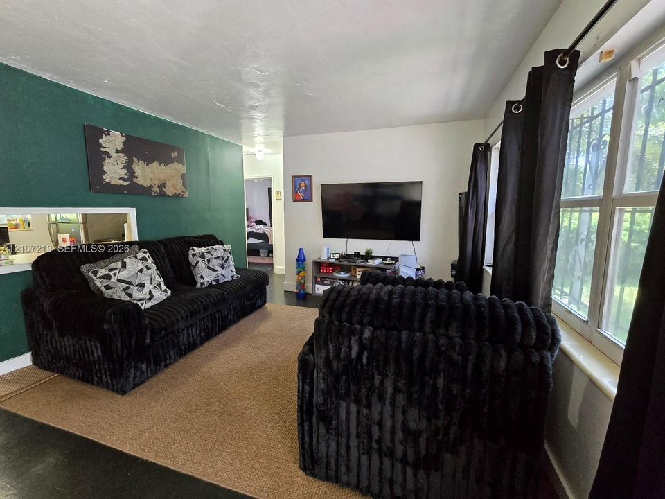 Living space featuring a prominent accent wall, dual-pane windows, and integrated interior pass-through window