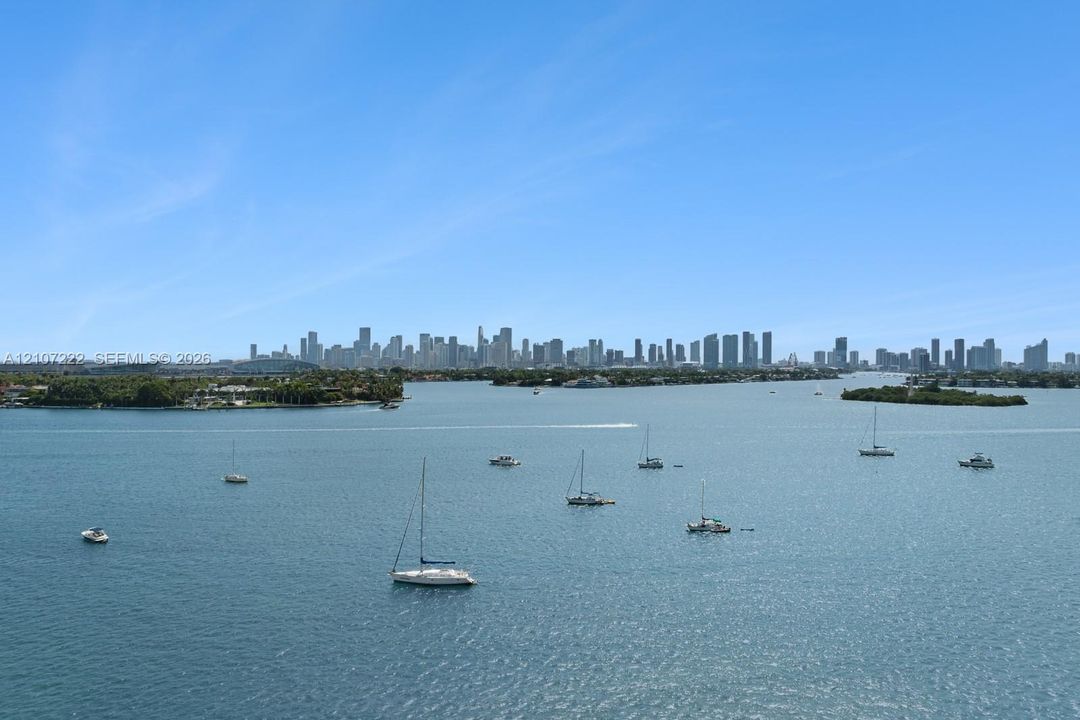 Expansive bayfront perspective featuring a panoramic skyline silhouette and open water with active marine traffic