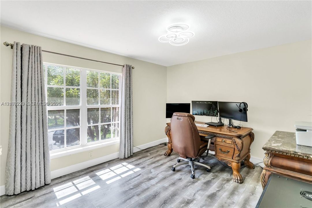 Multi-pane window, wood-finish flooring, and contemporary multi-ring flush mount lighting