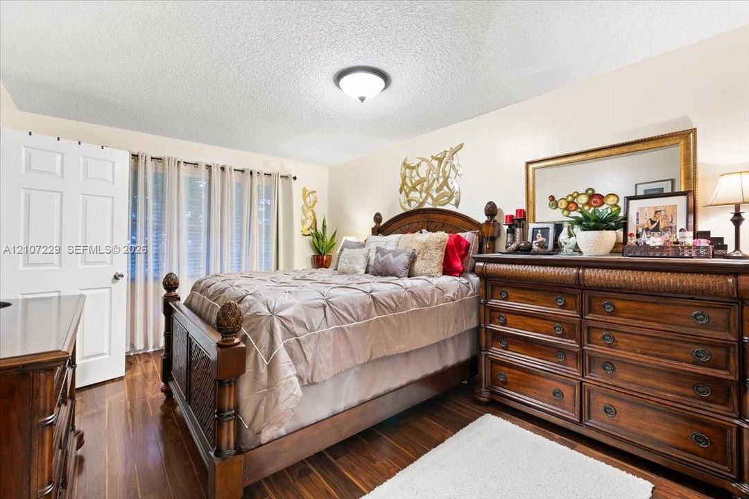 Room featuring dark wood-finish flooring, a textured ceiling, and a flush-mount light fixture
