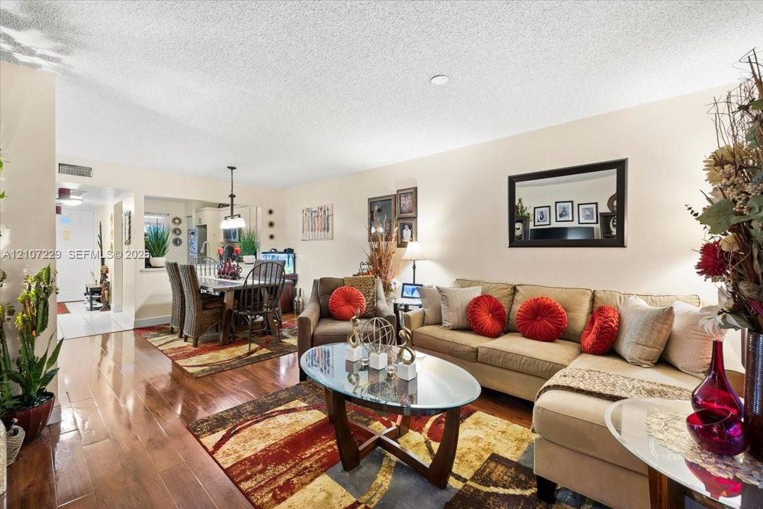 Open-concept interior featuring wood-finish flooring, a pass-through opening, and recessed ceiling lighting