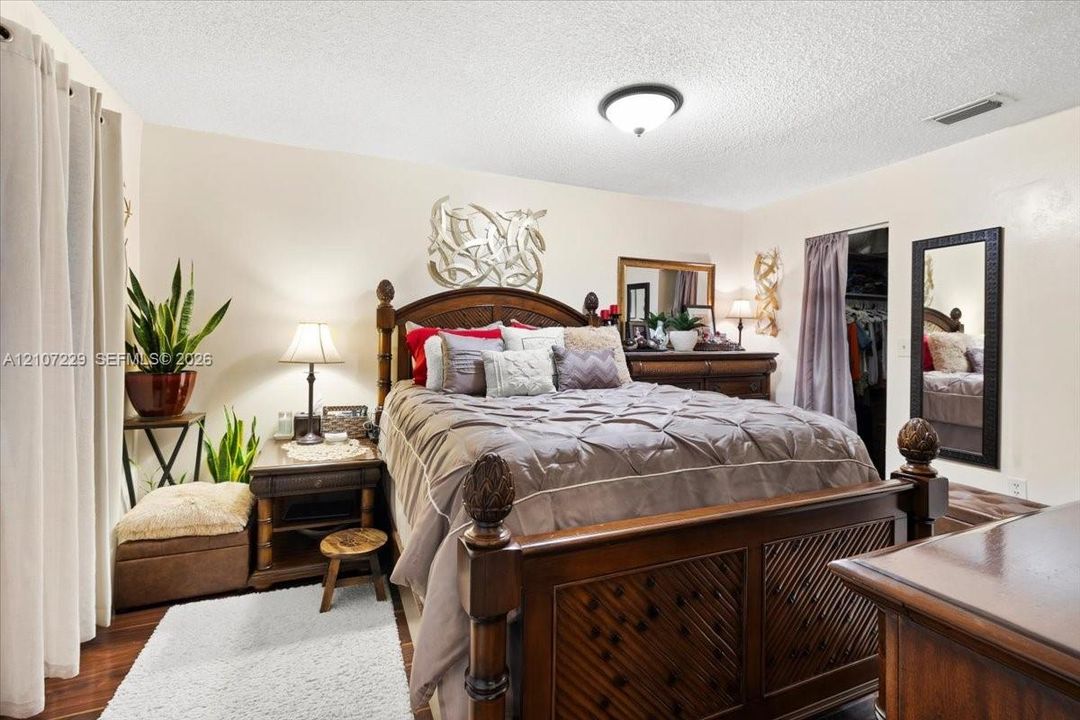 Neutral-toned walls, wood-finish flooring, and a flush-mount ceiling light fixture