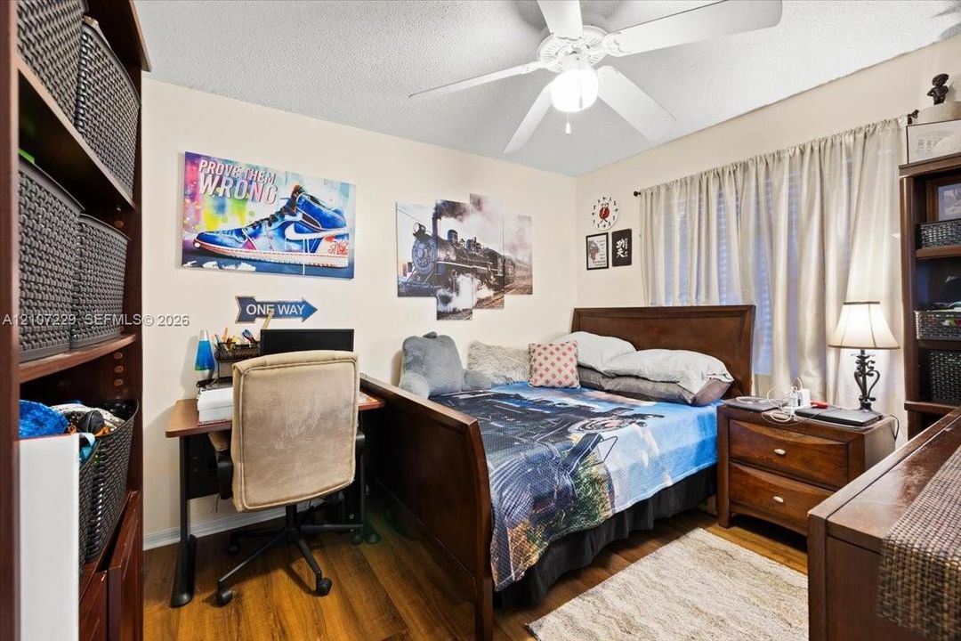 Room featuring wood-finish flooring and a ceiling-mounted light fixture with a fan