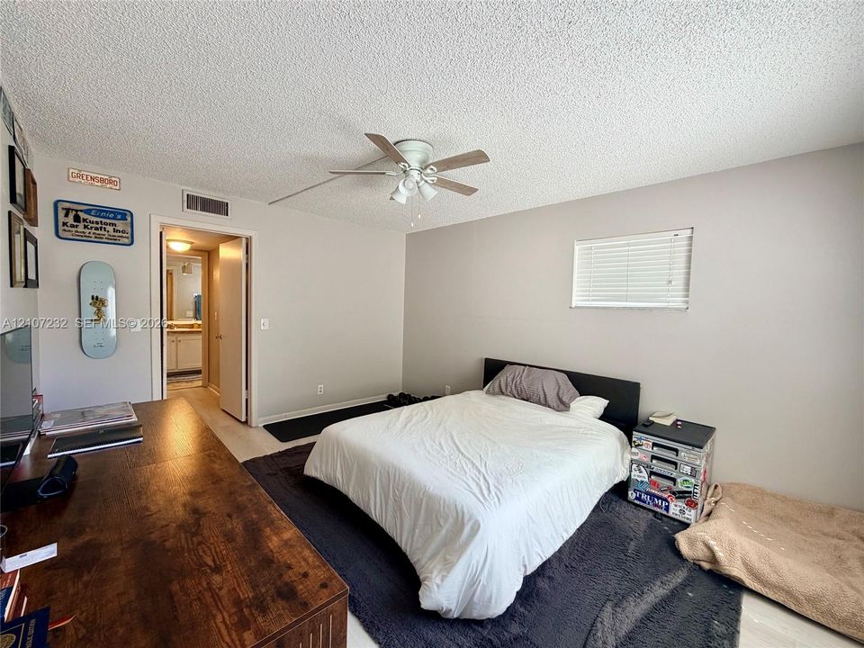 Room featuring neutral-toned walls, a ceiling fan with integrated lighting, and a horizontal window with blinds