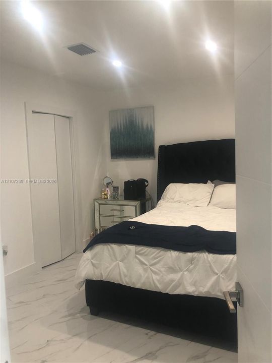 Interior room featuring stone-finish tile flooring, recessed ceiling lighting, and a bi-fold closet door