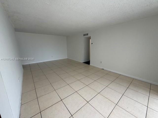 Open-concept interior featuring neutral wall paint and large-format ceramic floor tile