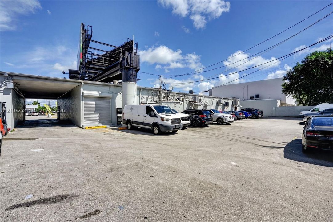 Paved surface lot with metal roll-up doors and an integrated covered loading area