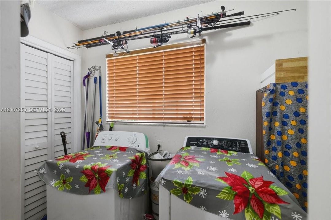 Laundry area featuring white bi-fold closet doors and horizontal window blinds