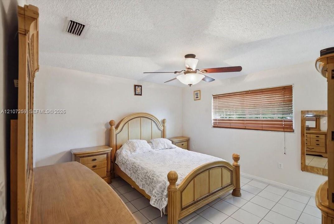 Ceramic tile flooring, ceiling fan with integrated light fixture, and horizontal window blinds
