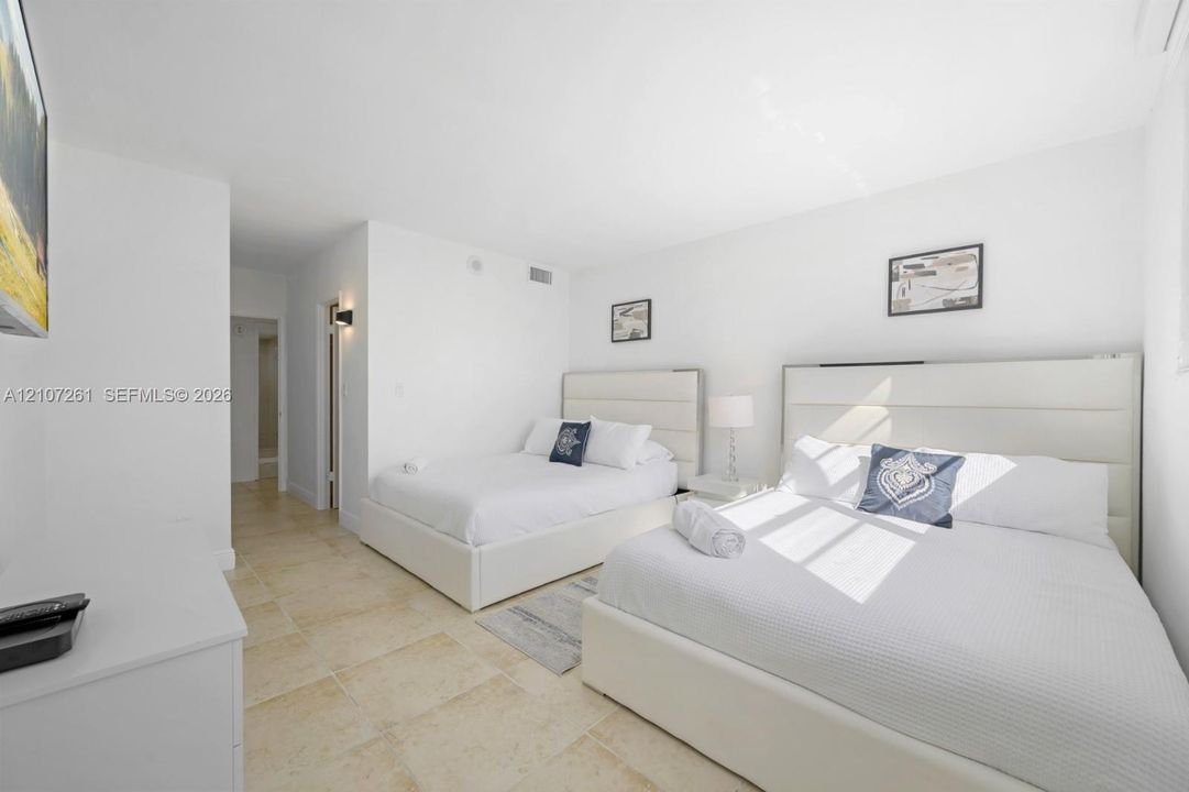 Neutral-toned stone flooring and wall-mounted lighting fixture